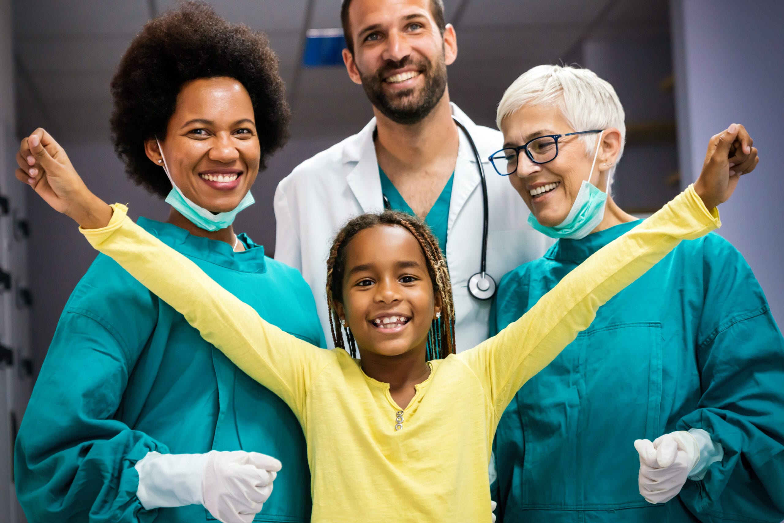 Team of experienced highly qualified doctors with child patient after a successful treatment Mature dentist with face mask talking to black female patient at dentist's office.