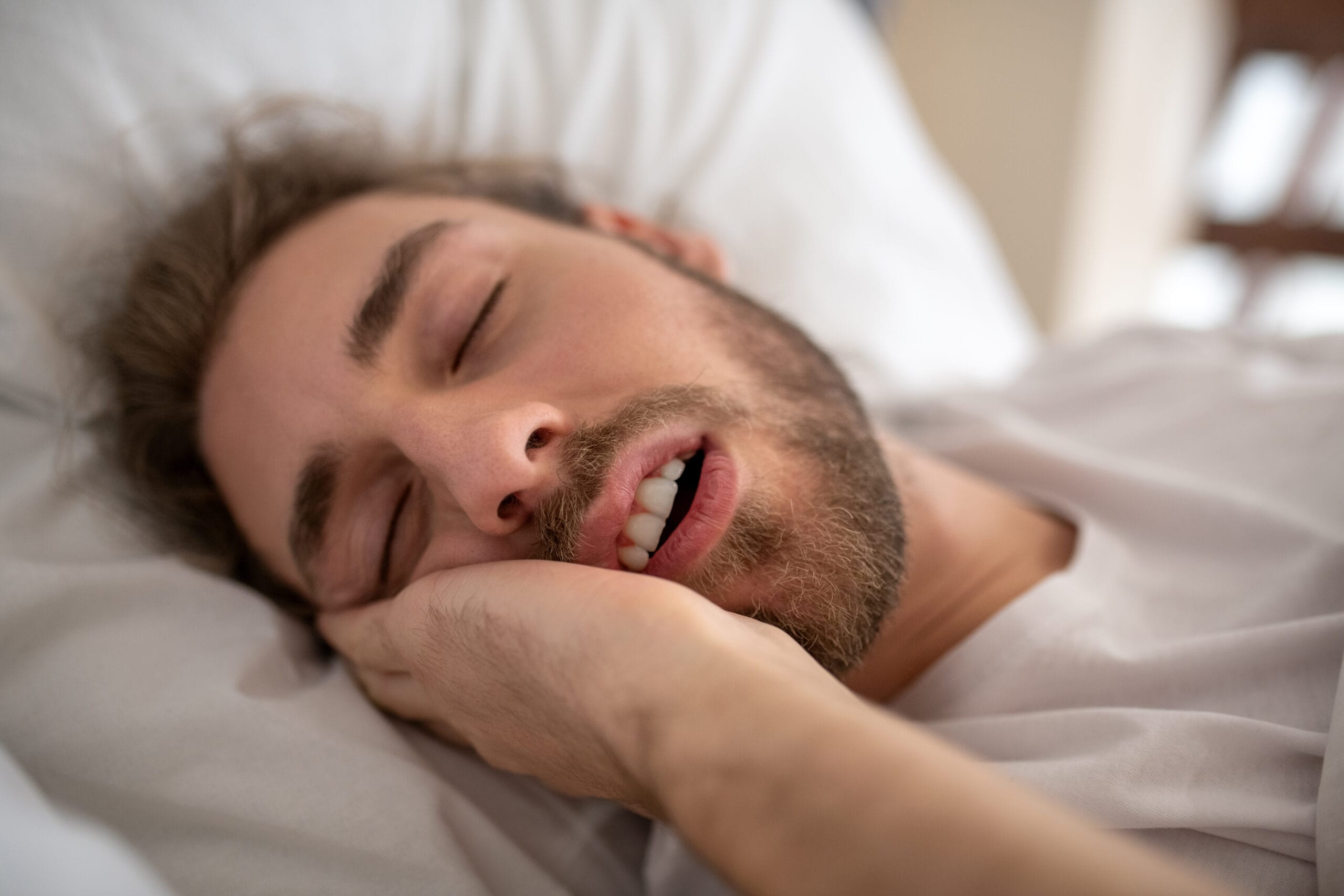 Young man sleeping in his bed in the morning