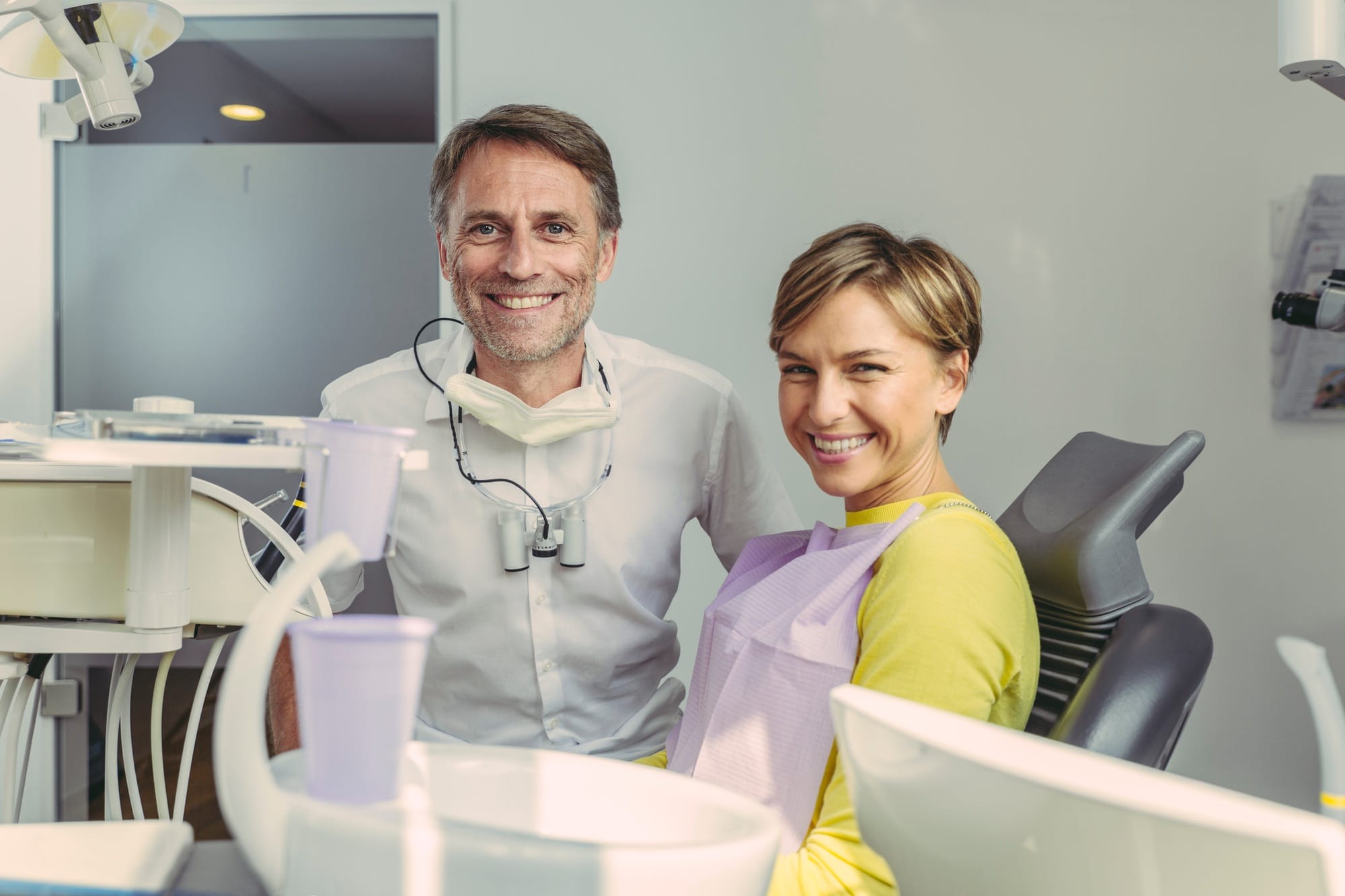 Dentist and patient smiling at camera, portrait Dentist and patient smiling at camera, portrait