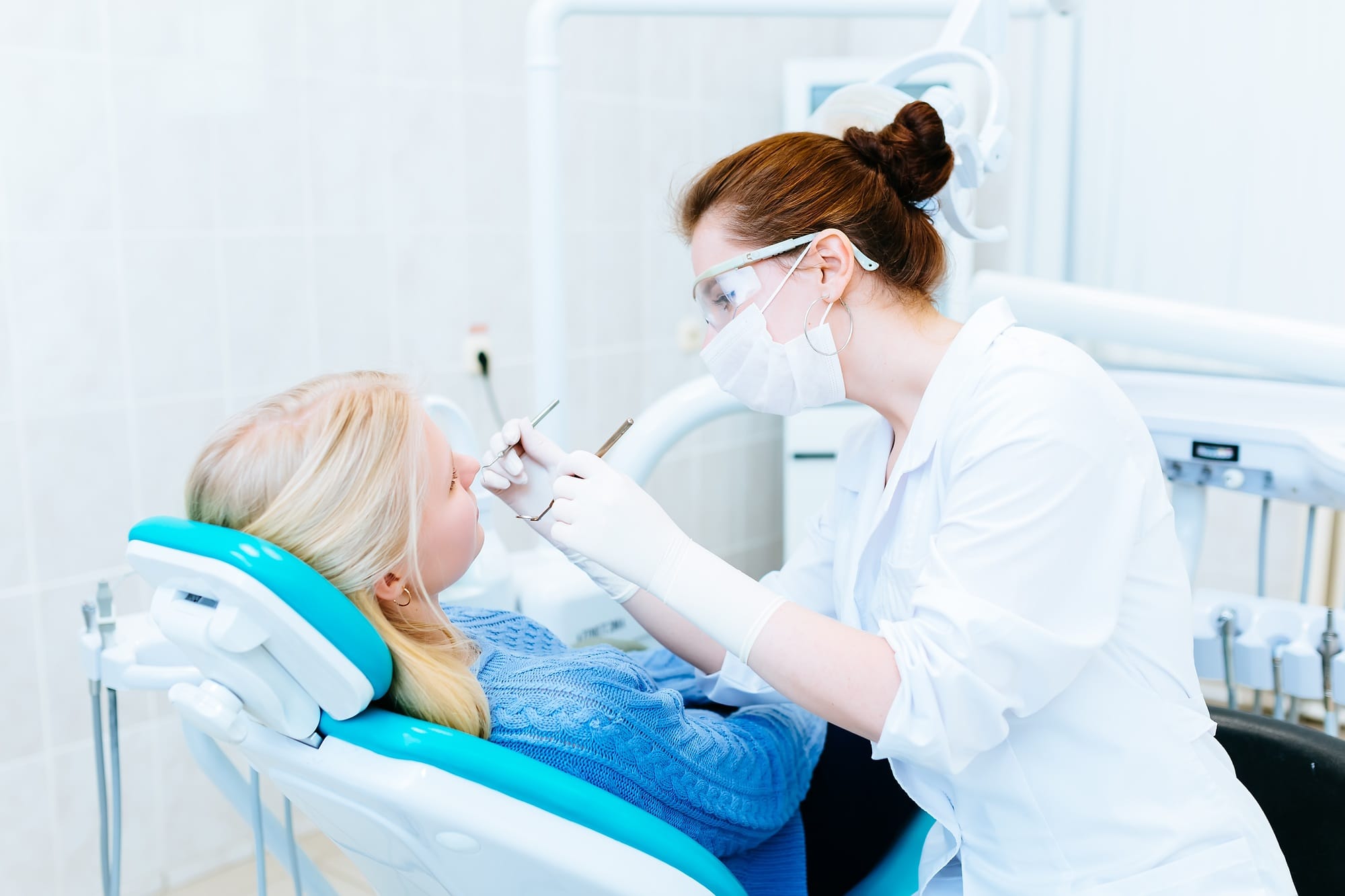 Dentist examining a patient's teeth in the clinic Dentist examining a patient's teeth in the clinic