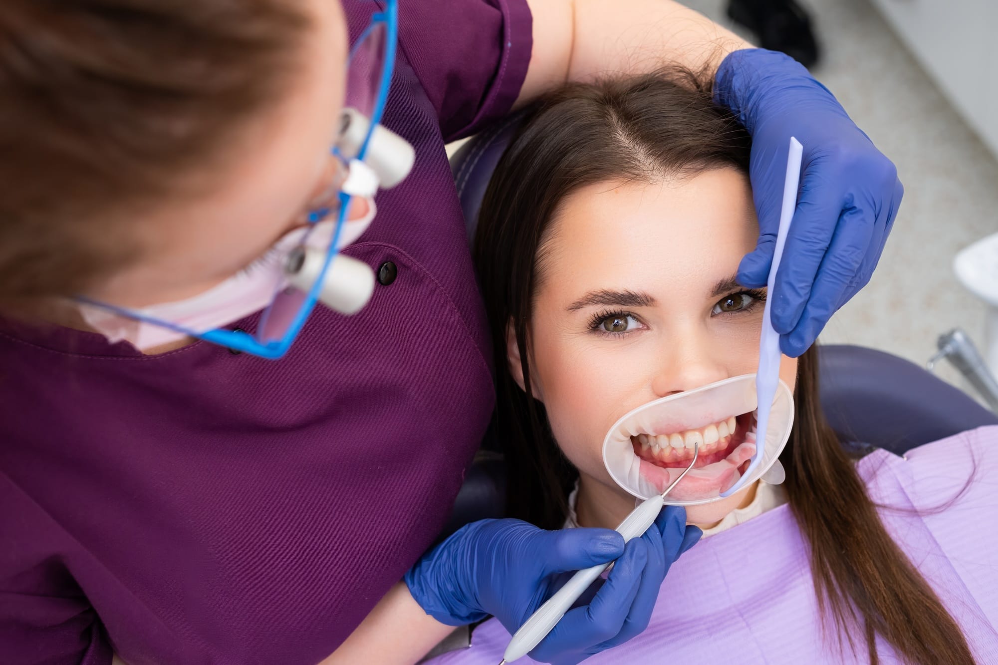 Dentist places temporary dental filling with instrument