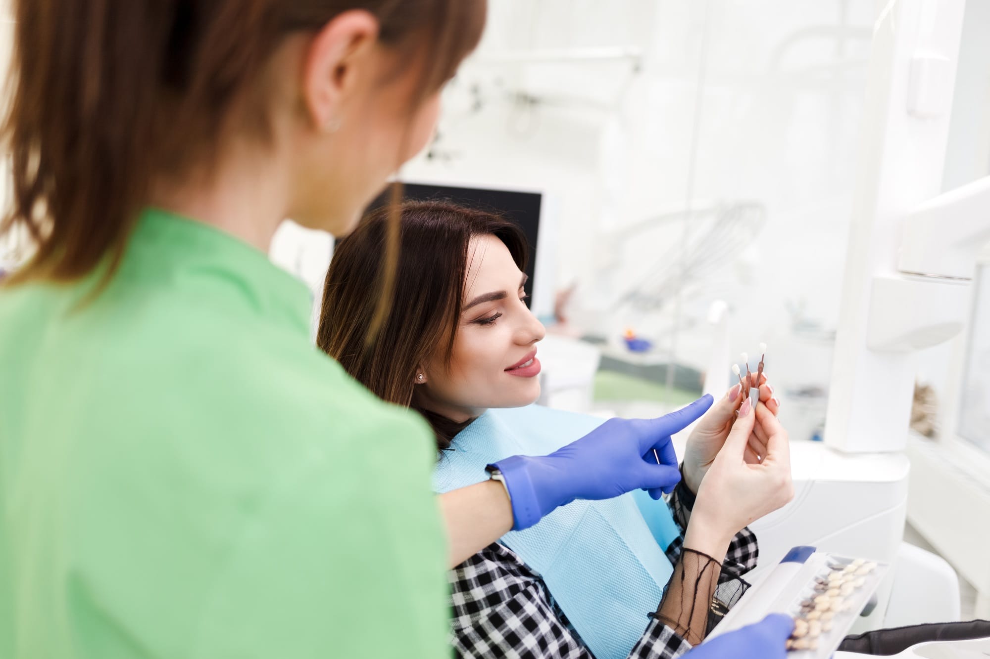 Dentist shows crown samples to his patient. Dentist shows crown samples to his patient.