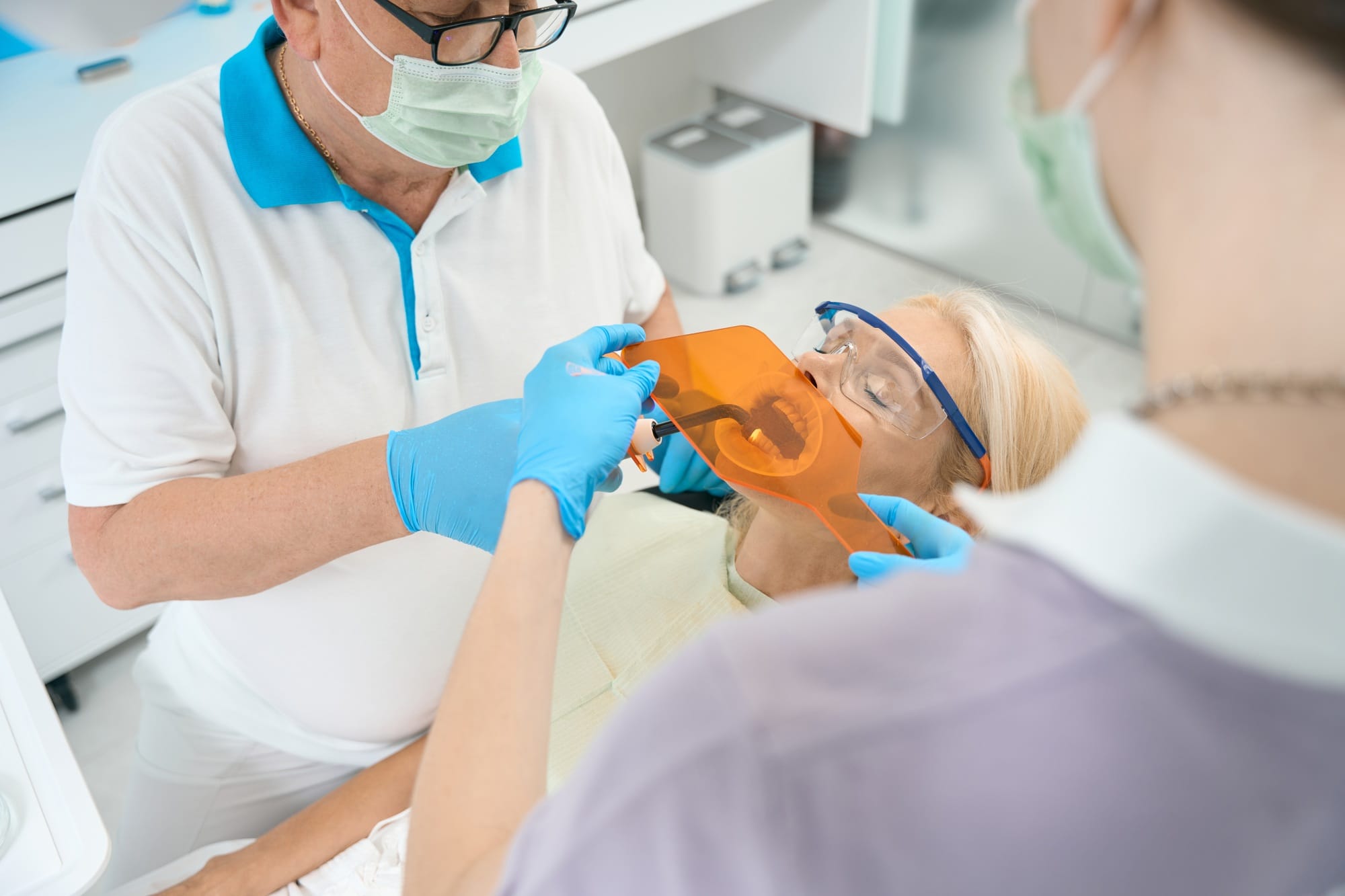 Focused stomatology team is making dental filling in medicine clinic Focused stomatology team is making dental filling in medicine clinic