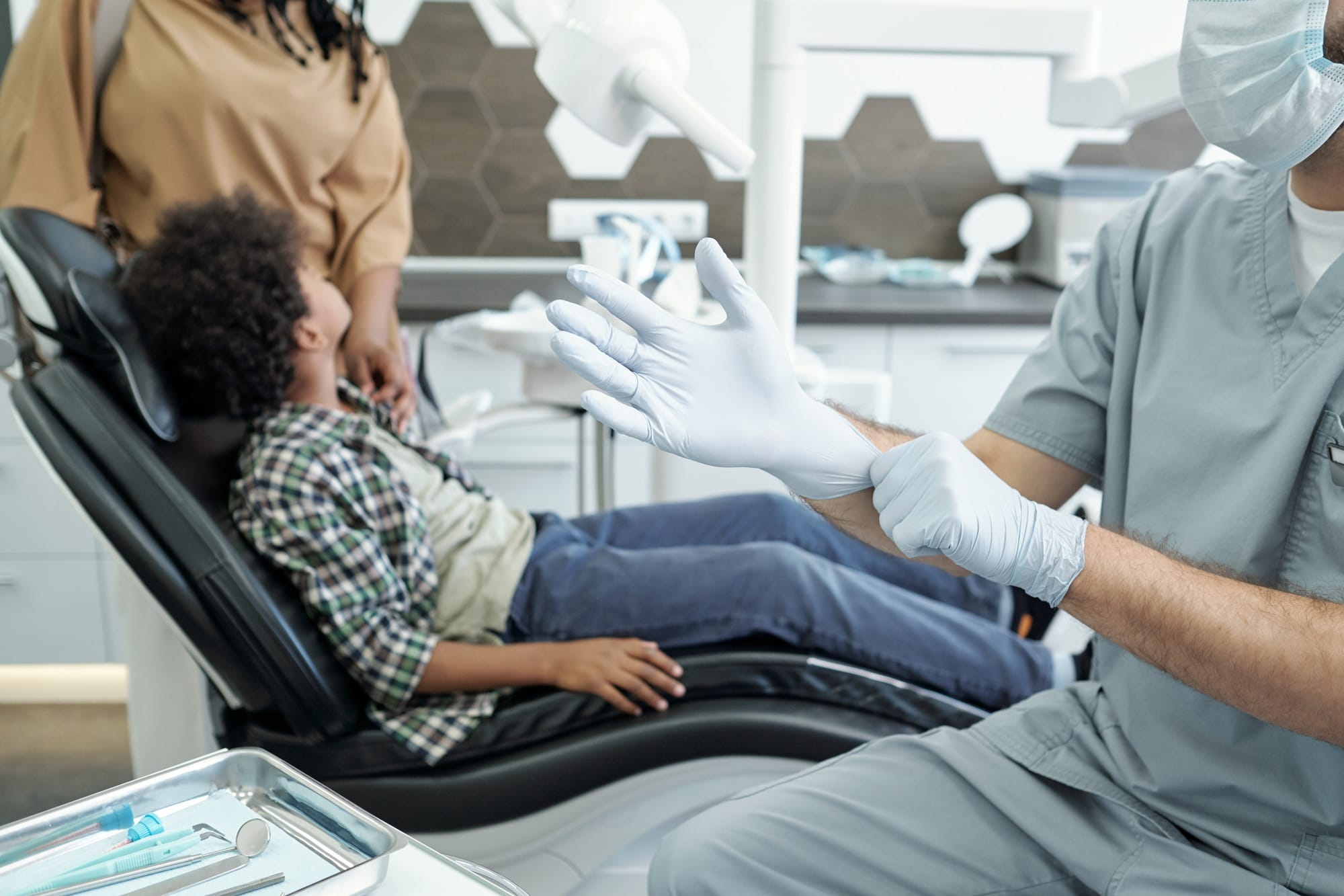 Hands of dentist putting on protective gloves before dental treatment Hands of dentist putting on protective gloves before dental treatment