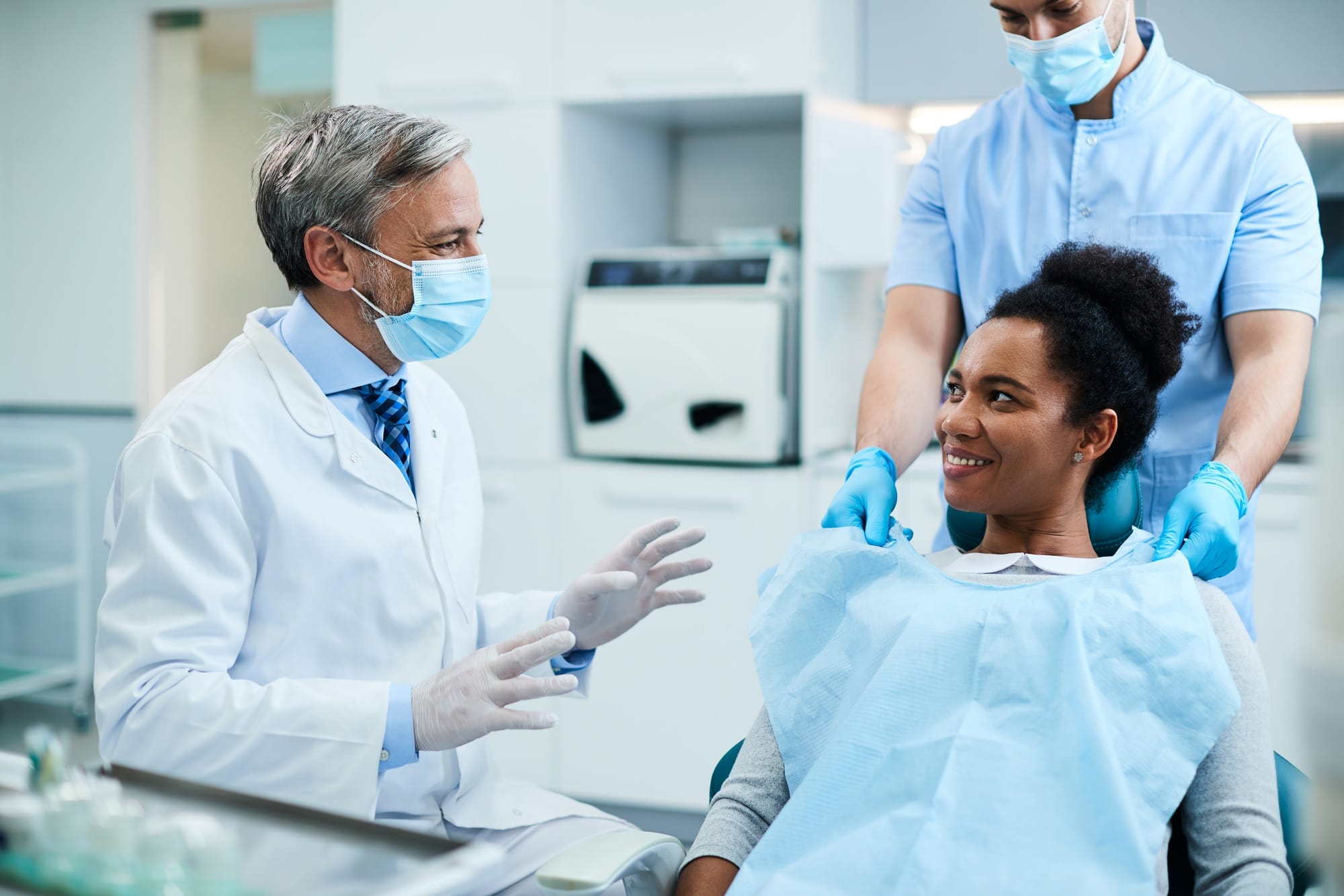 Happy black woman communicating with her dentist during appointment at dental clinic. Happy black woman communicating with her dentist during appointment at dental clinic.