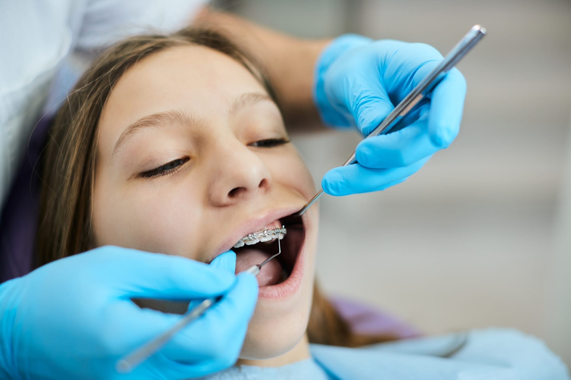 Little girl having her braces checked by orthodontist at dentist's office. Little girl having her braces checked by orthodontist at dentist's office.