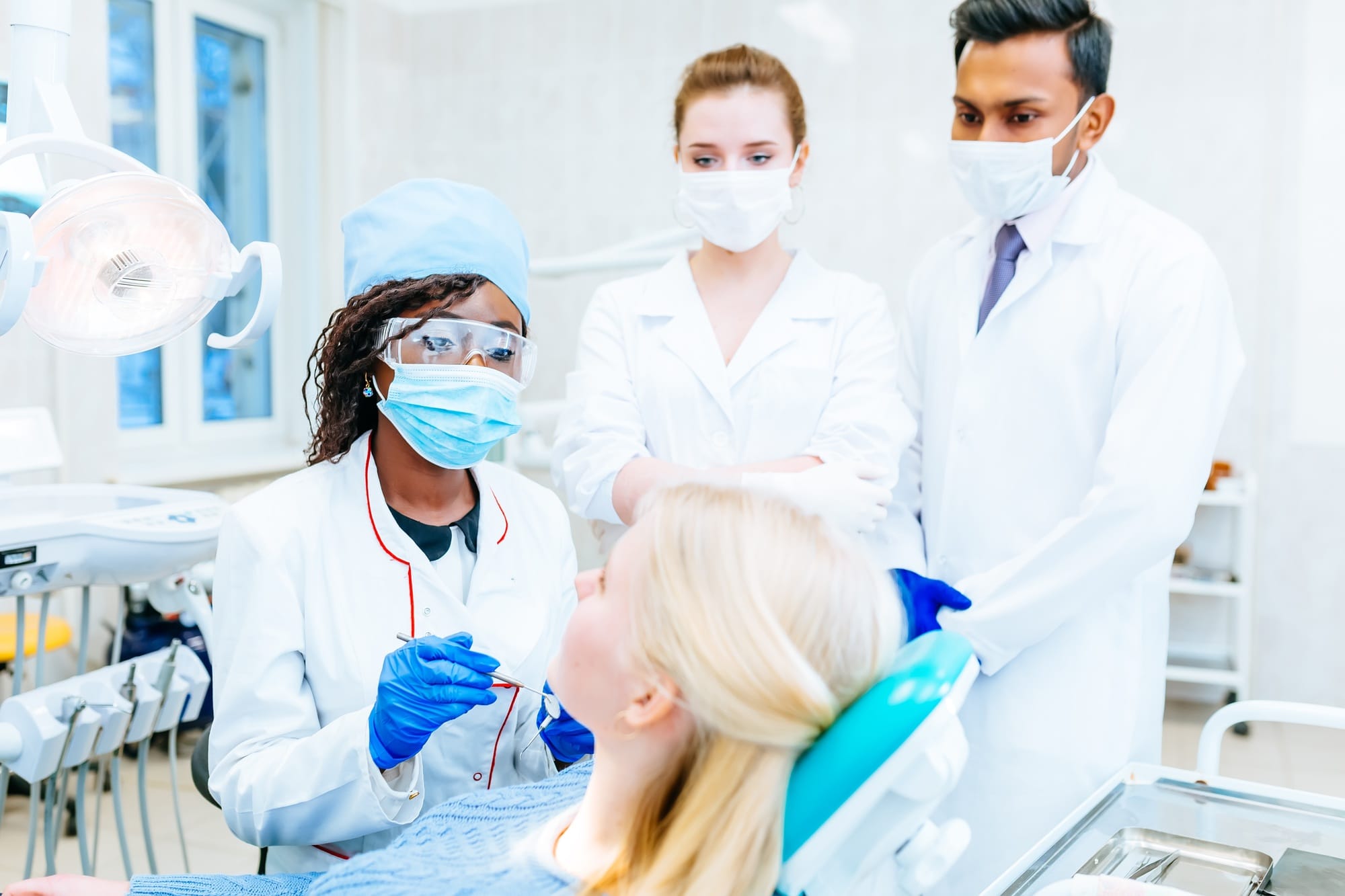 Multiracial dental team with patient in dental clinic. Dental health concept Multiracial dental team with patient in dental clinic. Dental health concept