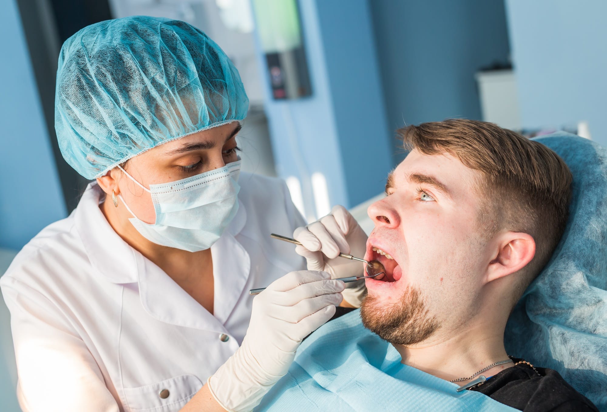 Overview of dental caries prevention. man at the dentist's chair during a dental procedure Overview of dental caries prevention. man at the dentist's chair during a dental procedure