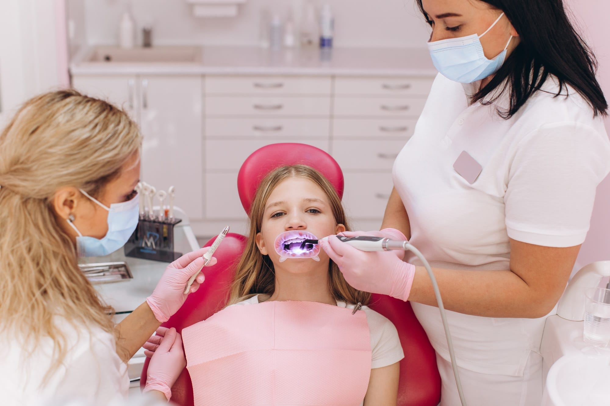 Teenage girl doing ultraviolet teeth whitening at a dental clinic Teenage girl doing ultraviolet teeth whitening at a dental clinic