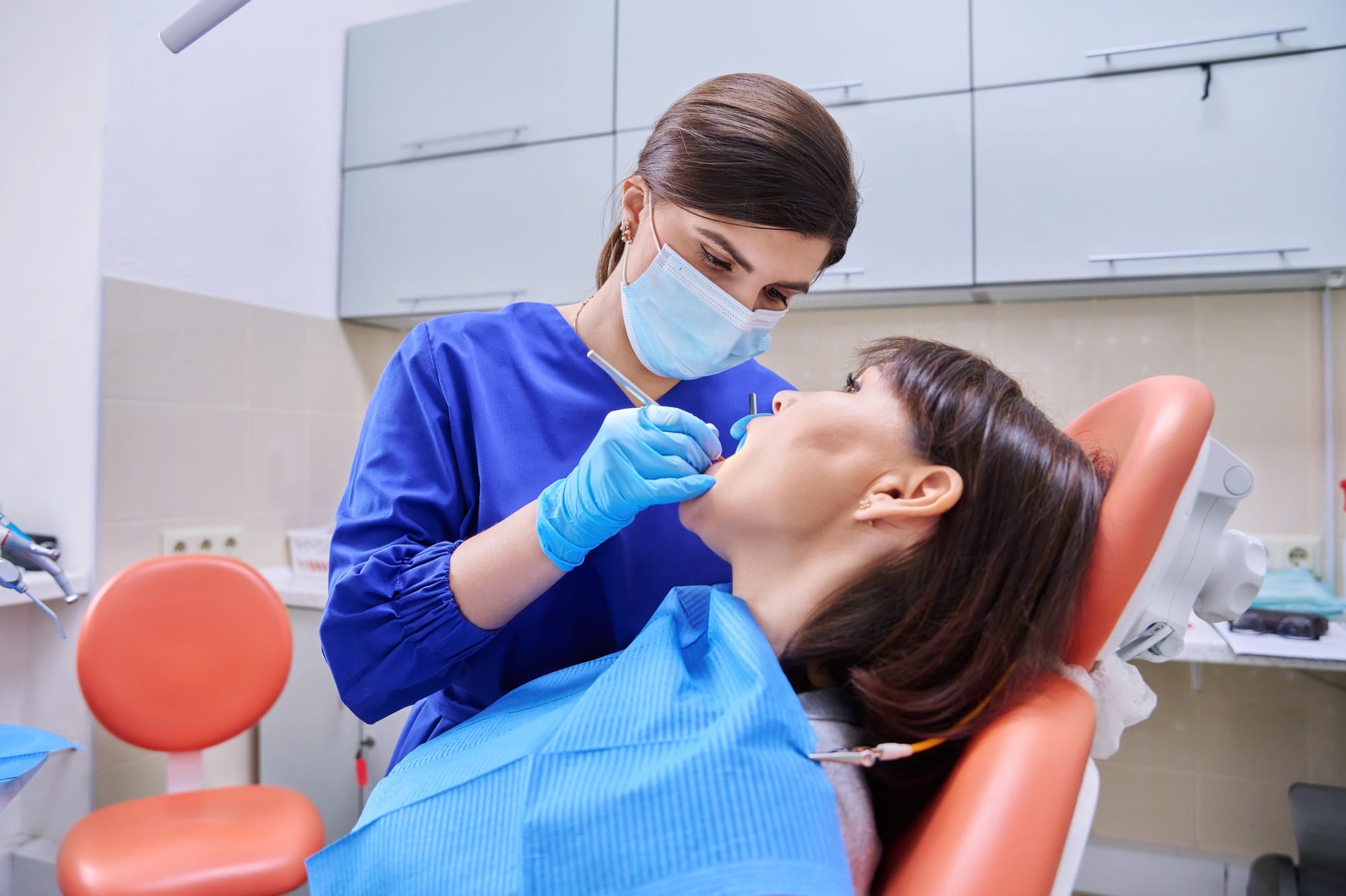 Woman patient treating teeth in clinic, treatment process Woman patient treating teeth in clinic, treatment process