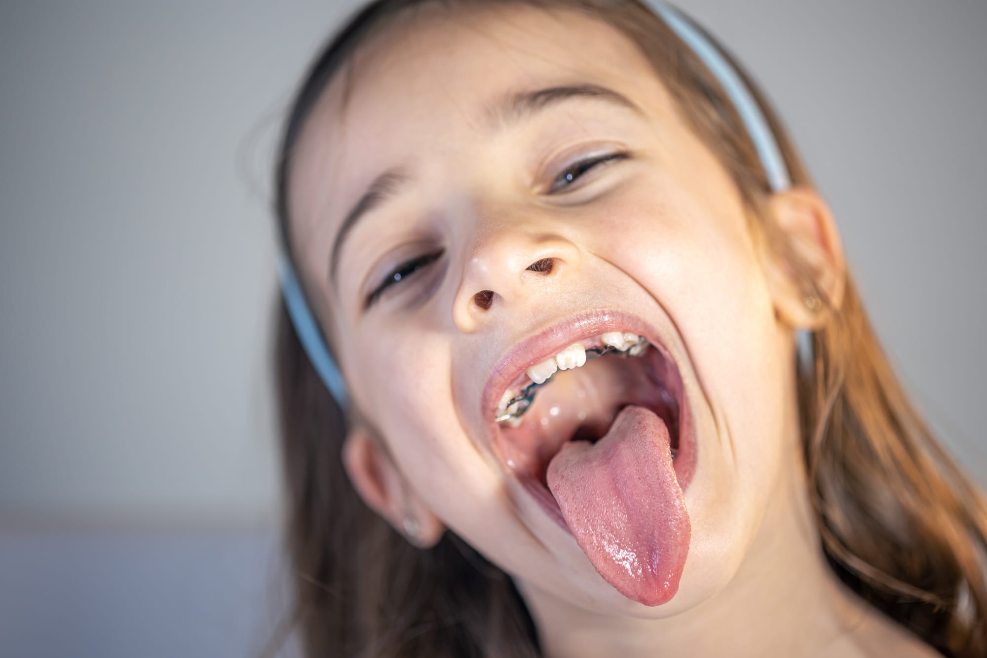 A child girl open her mouth and show her tounge. A child girl open her mouth and show her tounge.