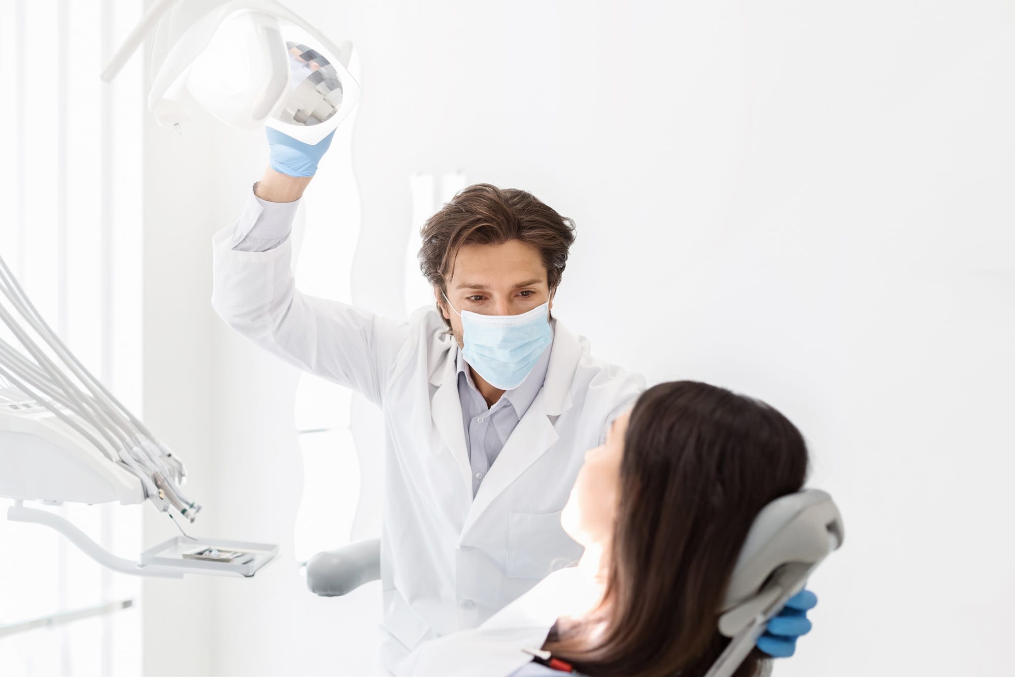 Attentive dentist listening to female patient in cabinet Attentive dentist listening to female patient in cabinet