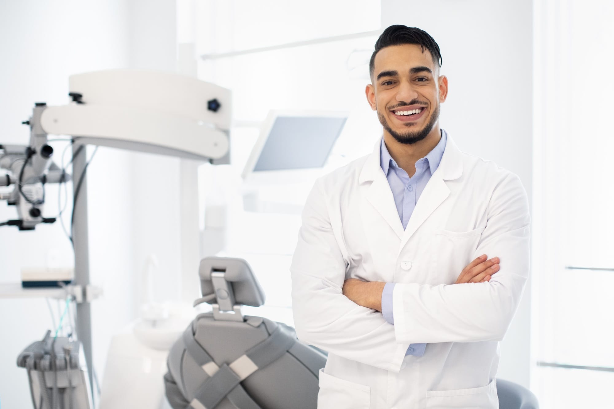 Dental Center. Portrait Of Smiling Middle Eastern Dentist Doctor Posing At Workplace Dental Center. Portrait Of Smiling Middle Eastern Dentist Doctor Posing At Workplace