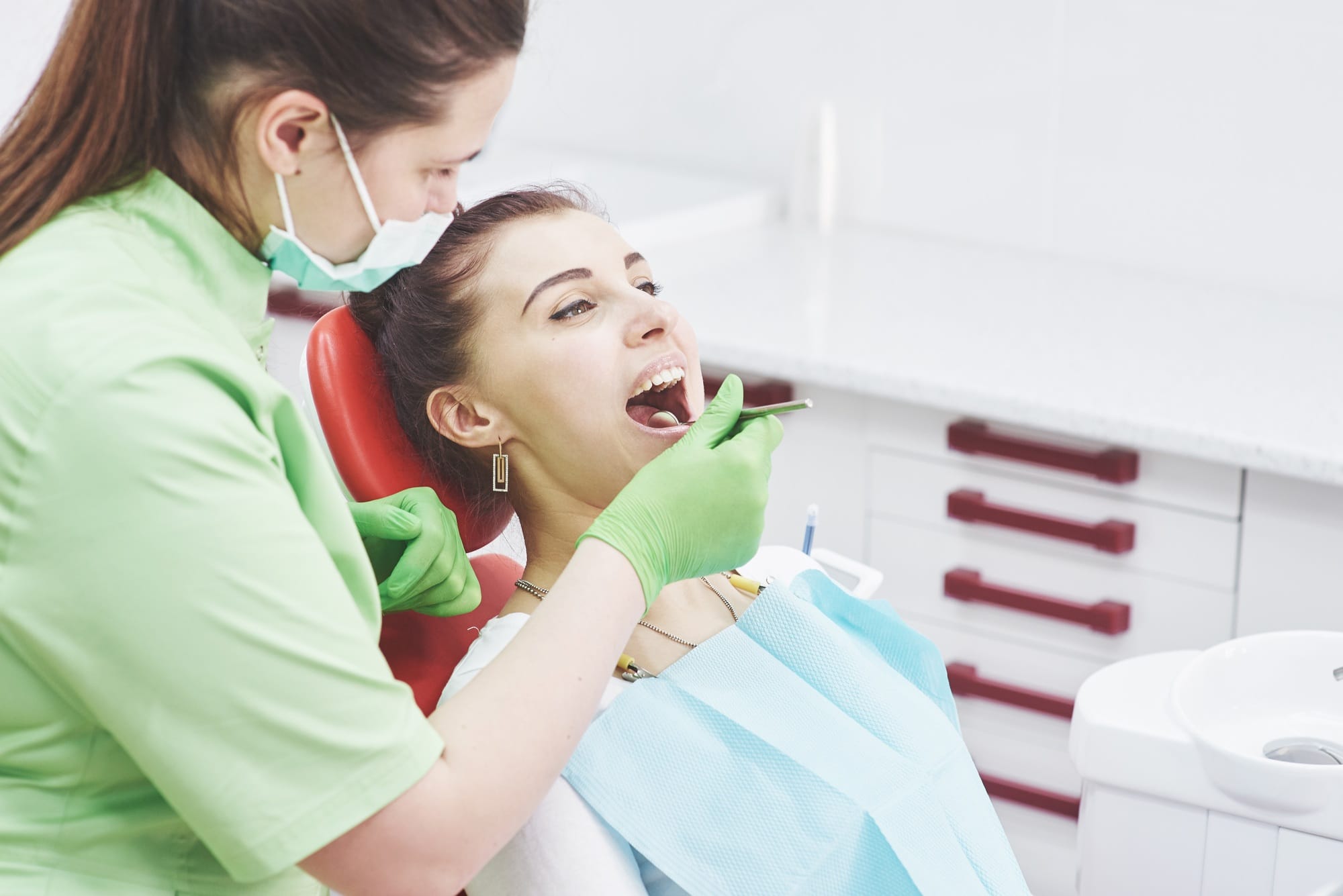 Dentist curing a female patient in the stomatology. Early prevention and oral hygiene concept Dentist curing a female patient in the stomatology. Early prevention and oral hygiene concept