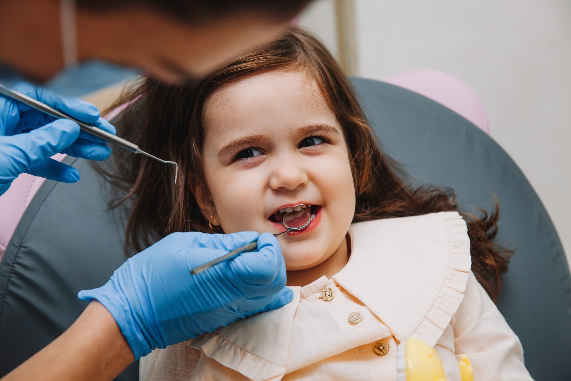 dentist, doctor examines the oral cavity of a little girl, uses a mouth mirror, baby teeth close-up, dentist, doctor examines the oral cavity of a little girl, uses a mouth mirror, baby teeth close-up,