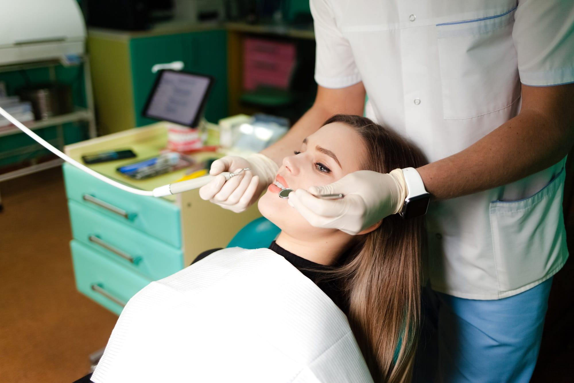 Dentist removes tartar from his patient’s teeth