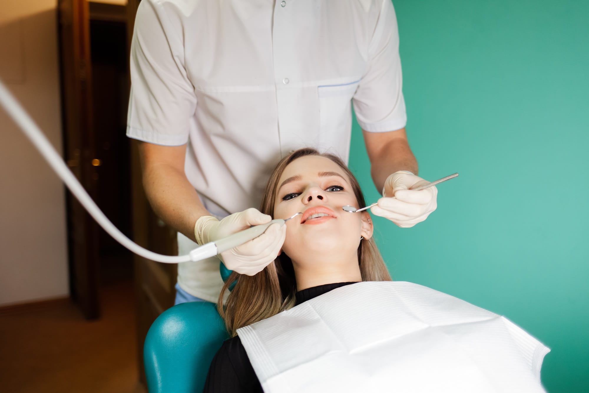 Dentist removes tartar from his patient’s teeth