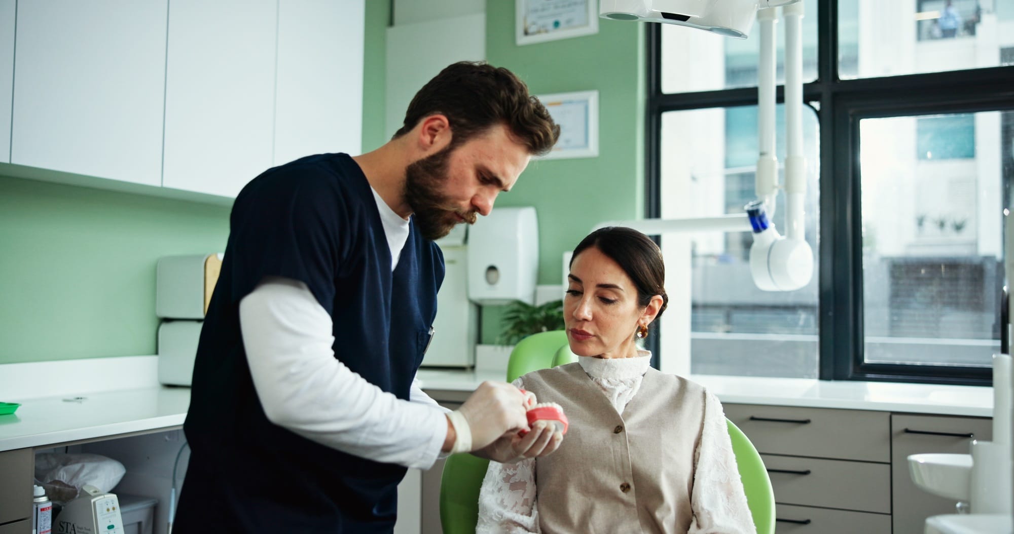 Dentist, teeth mold and man with woman in clinic for cleaning demonstration, dental hygiene and gum Dentist, teeth mold and man with woman in clinic for cleaning demonstration, dental hygiene and gum