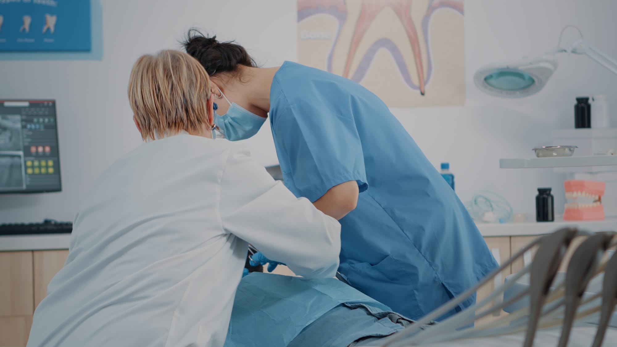Dentistry team doing teeth extraction on patient with toothache Dentistry team doing teeth extraction on patient with toothache