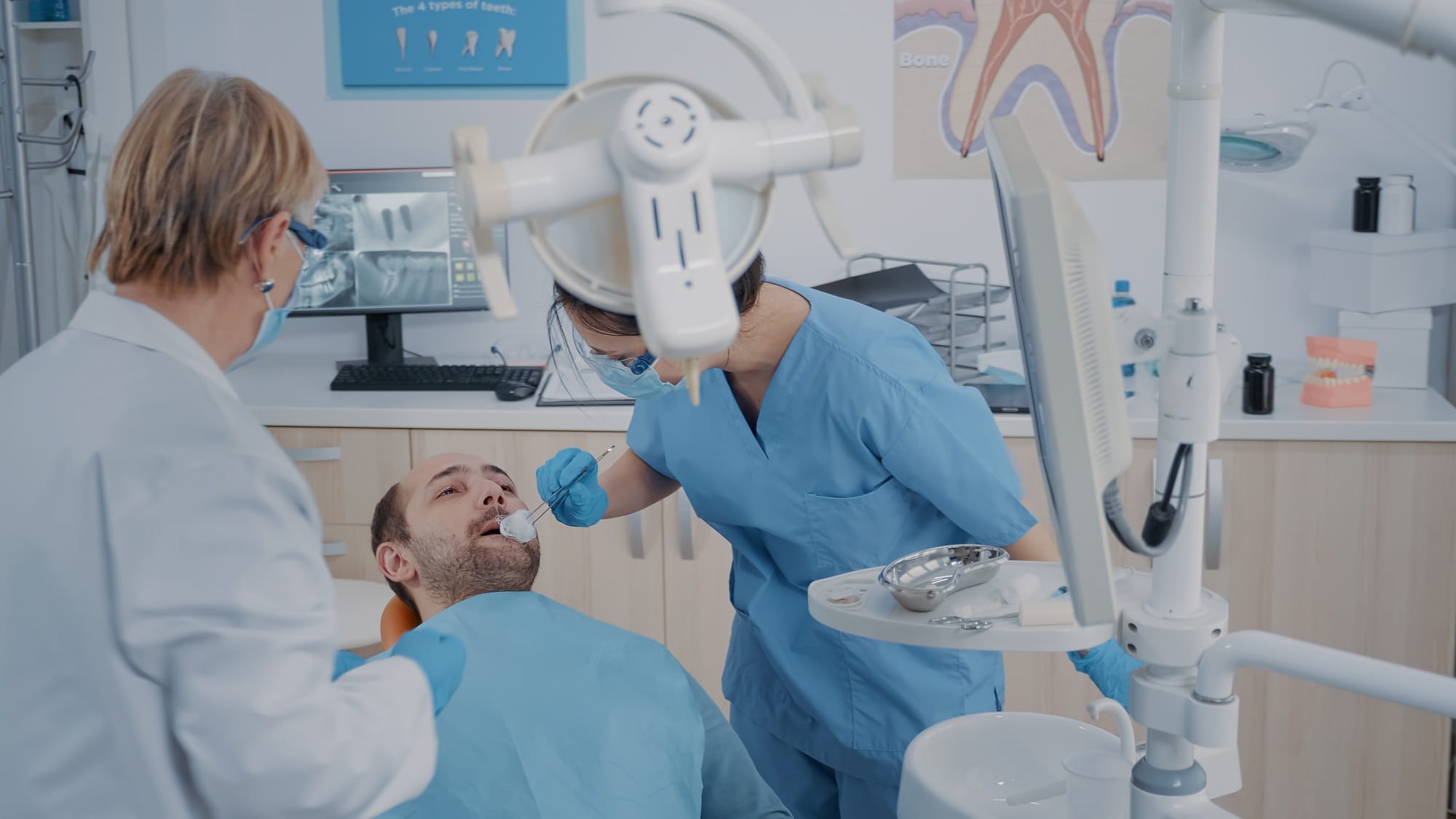 Dentistry team performing tooth extraction in stomatology cabinet Dentistry team performing tooth extraction in stomatology cabinet