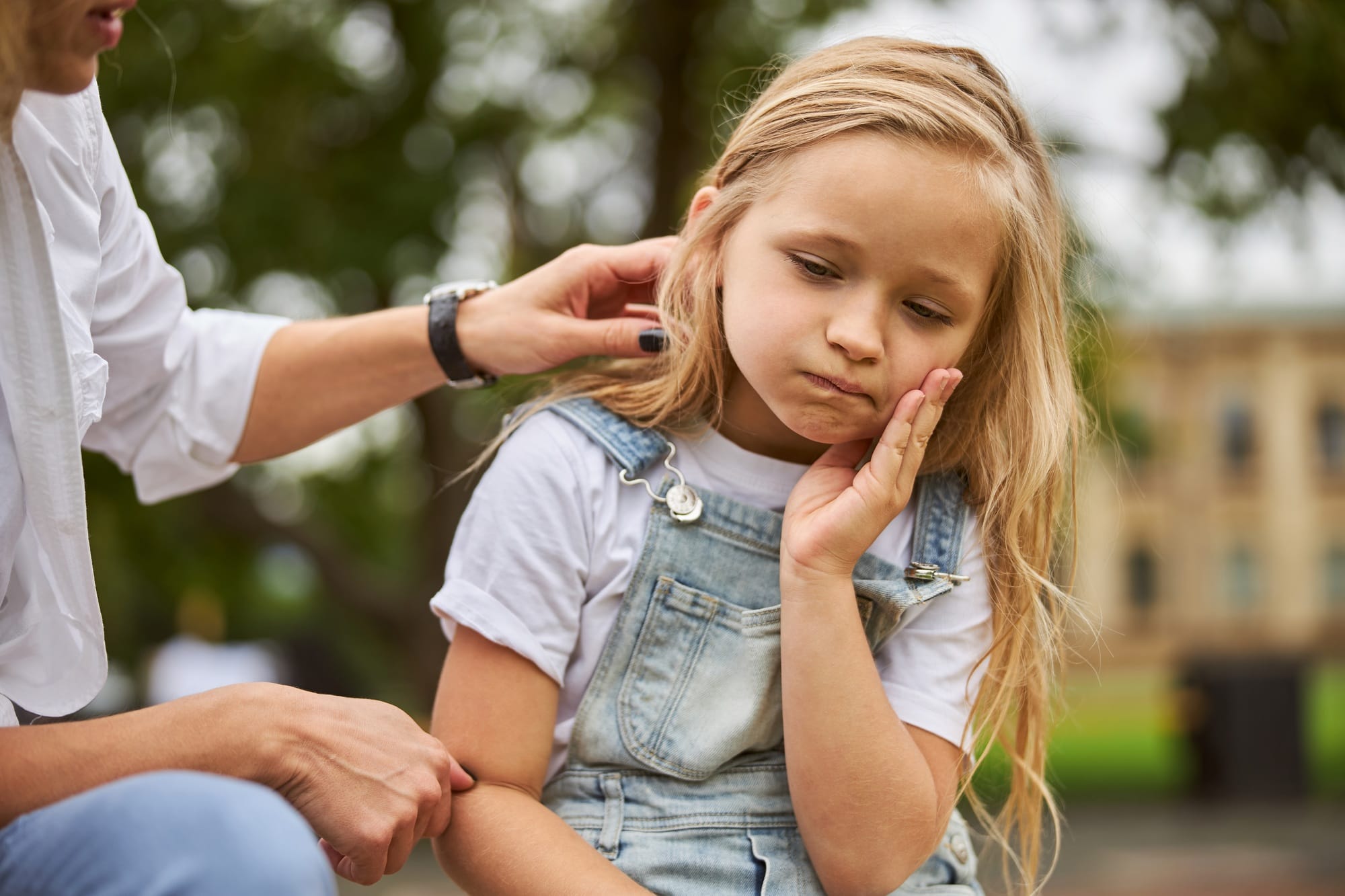 Female child holding hand on the face while feeling pain in the teeth Female child holding hand on the face while feeling pain in the teeth