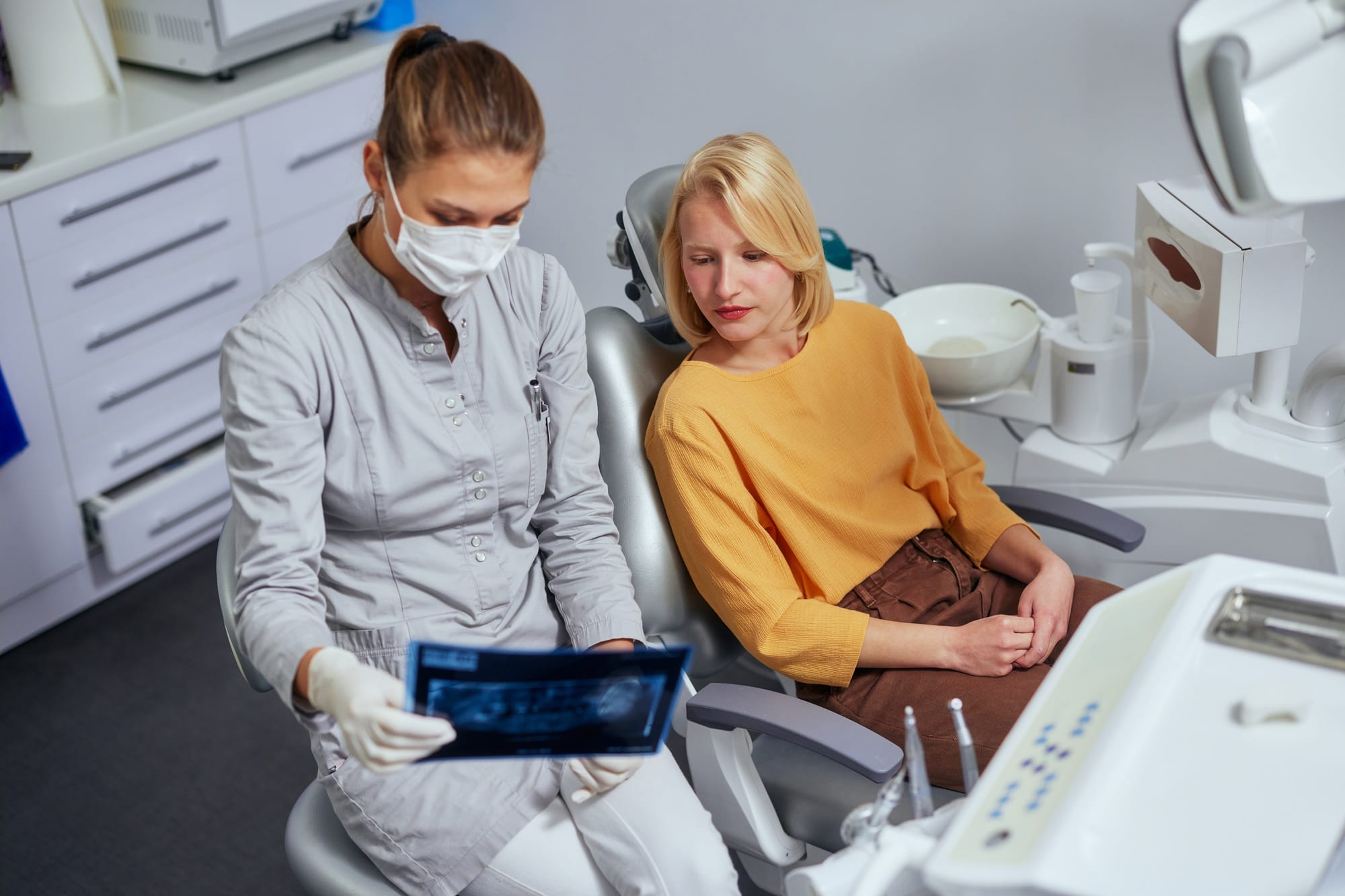 Female dentist showing dental X-ray Image to patient
