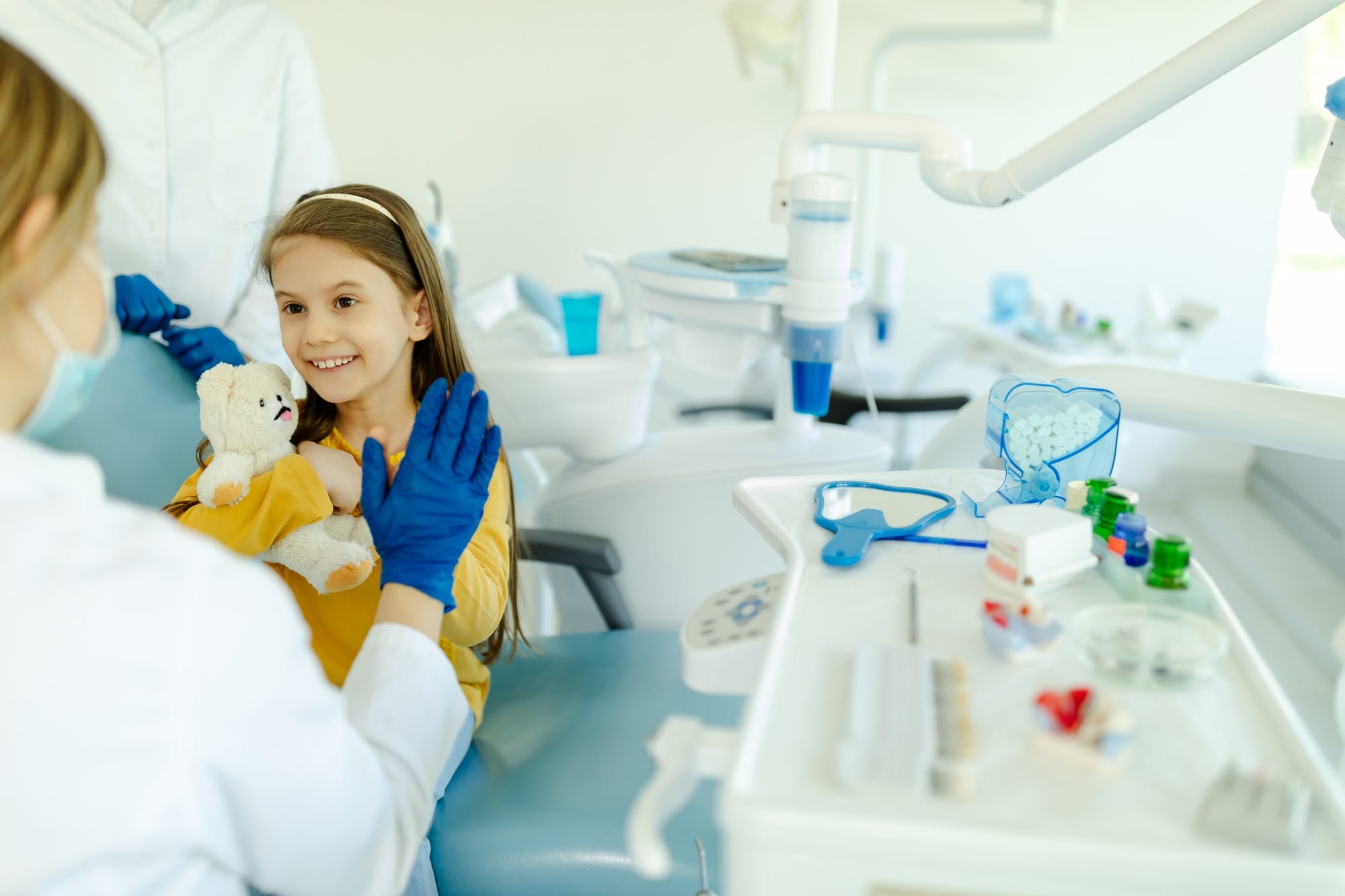 Female doctor is giving hi five to little girl after a successful dental examination. Female doctor is giving hi five to little girl after a successful dental examination.