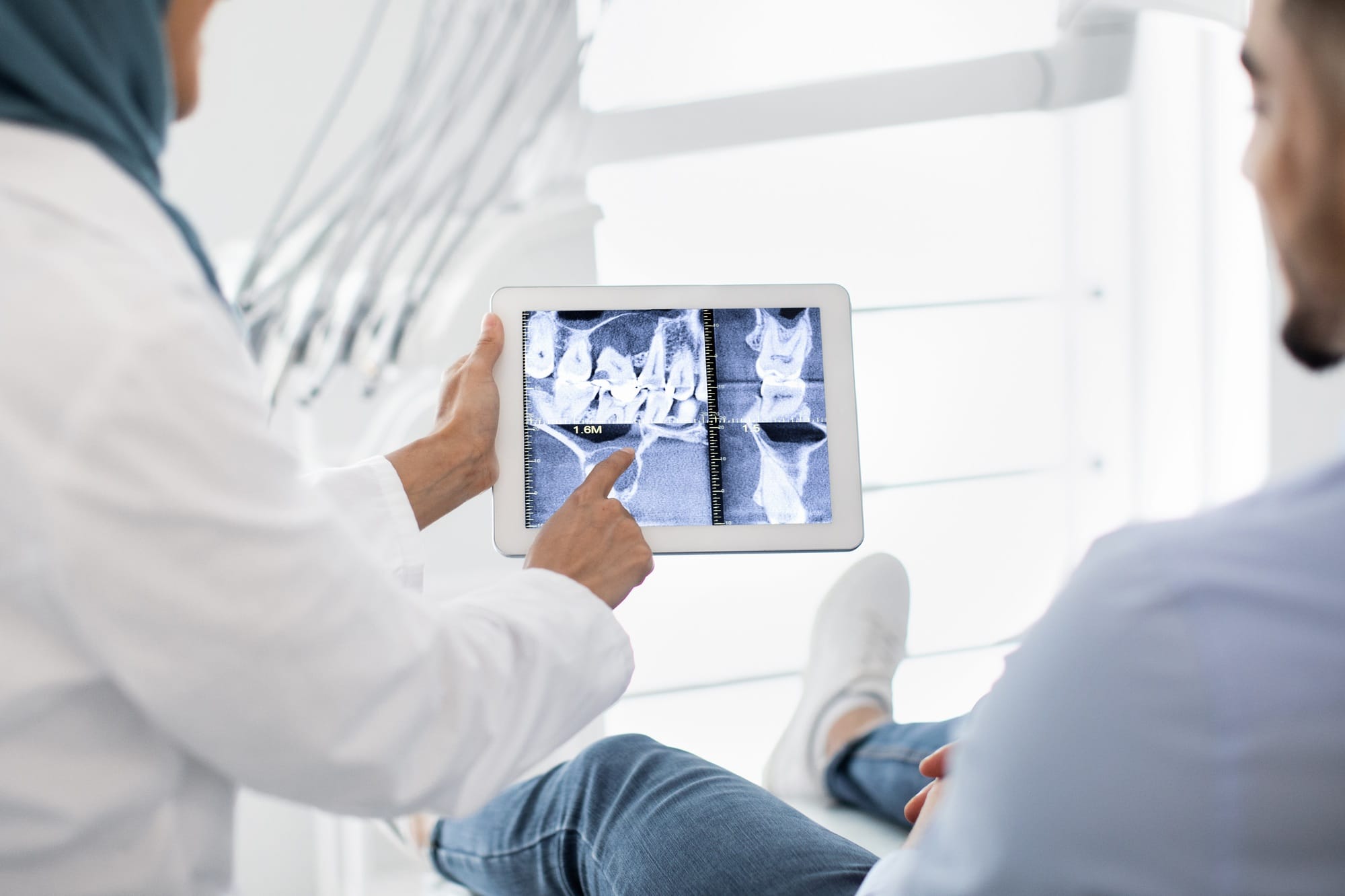 Oral Surgery. Female Dentist In Hijab Demonstrating Teeth Xray On Digital Tablet Oral Surgery. Female Dentist In Hijab Demonstrating Teeth Xray On Digital Tablet