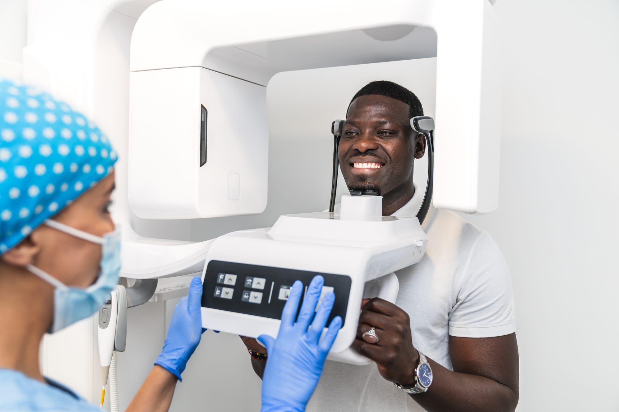 Patient undergoing a 3D dental scan while being assisted by a dental hygienist in the clinic.