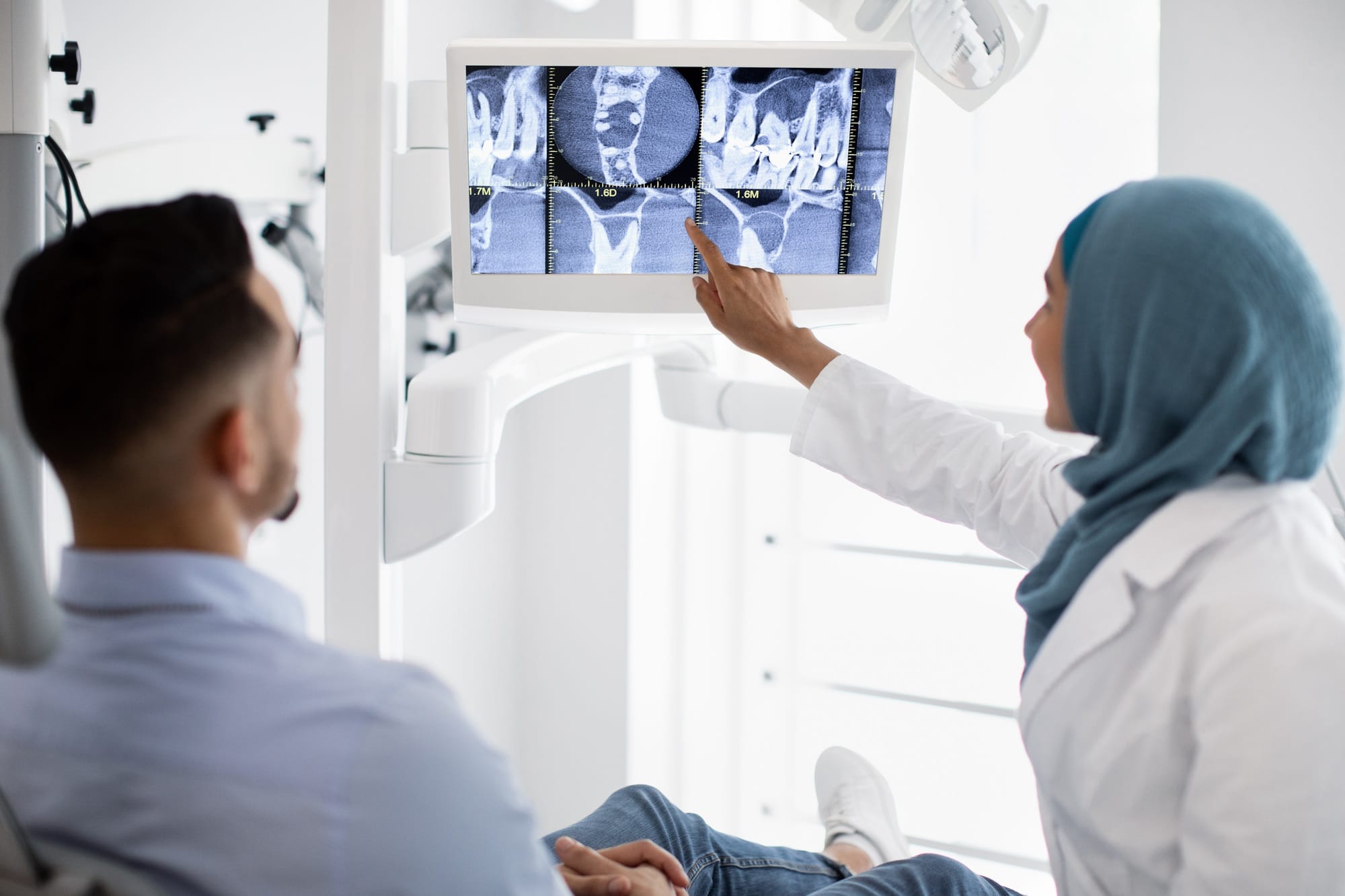 Root Canal Treatment. Muslim Female Dentist Showing Xray Picture On Digital Monitor Root Canal Treatment. Muslim Female Dentist Showing Xray Picture On Digital Monitor