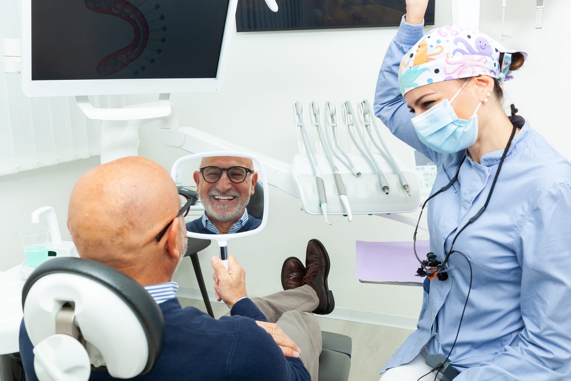 Senior man admiring his new smile after dental implant surgery