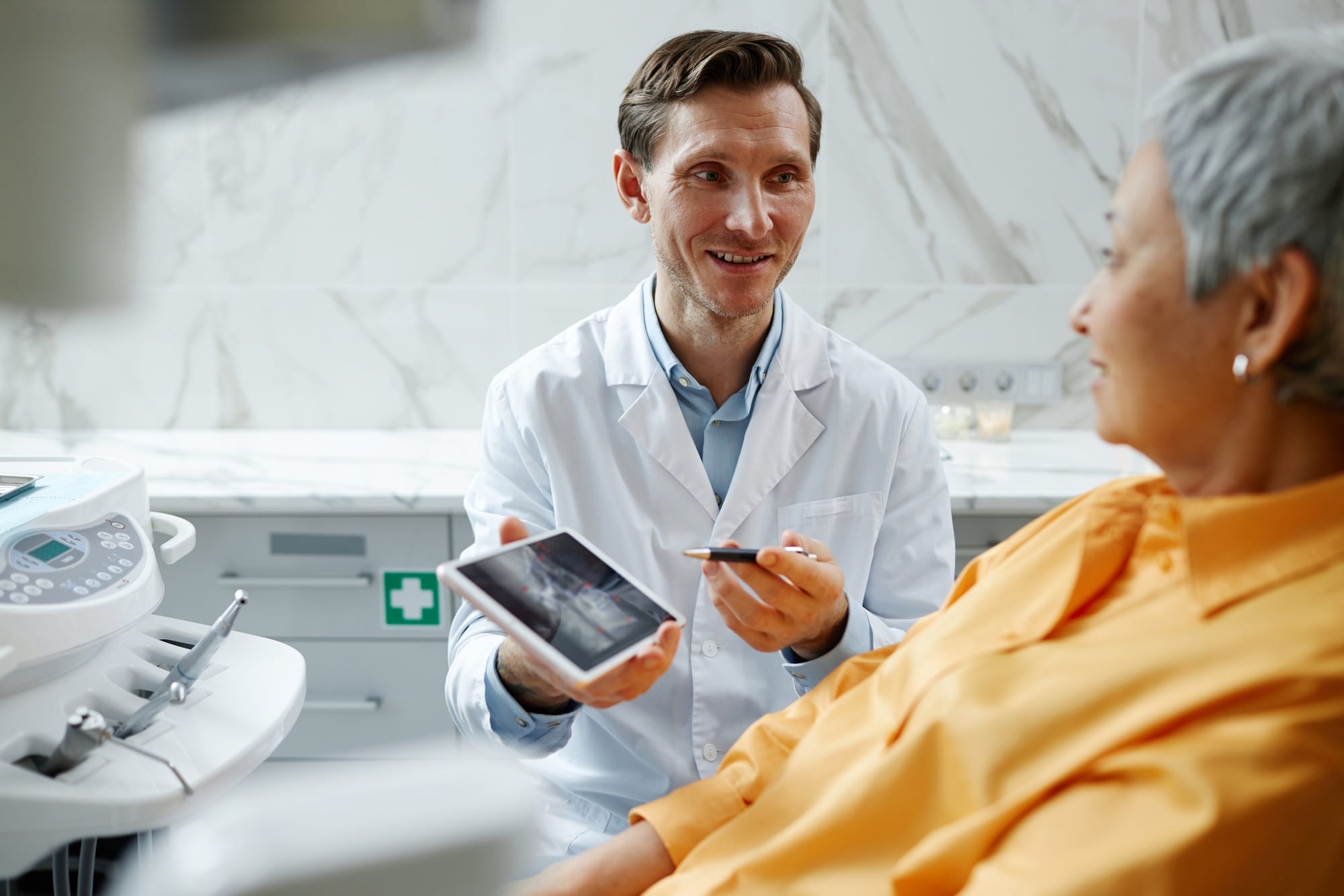 Smiling male dentist holding digital tablet with teeth x-ray image Smiling male dentist holding digital tablet with teeth x-ray image