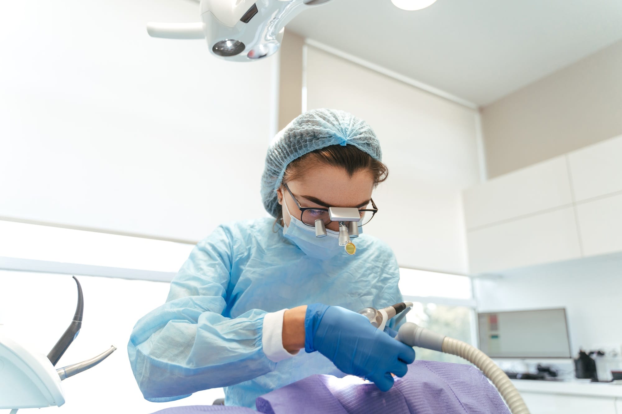 Woman dentist in protective clothes making professional teeth cleaning Woman dentist in protective clothes making professional teeth cleaning