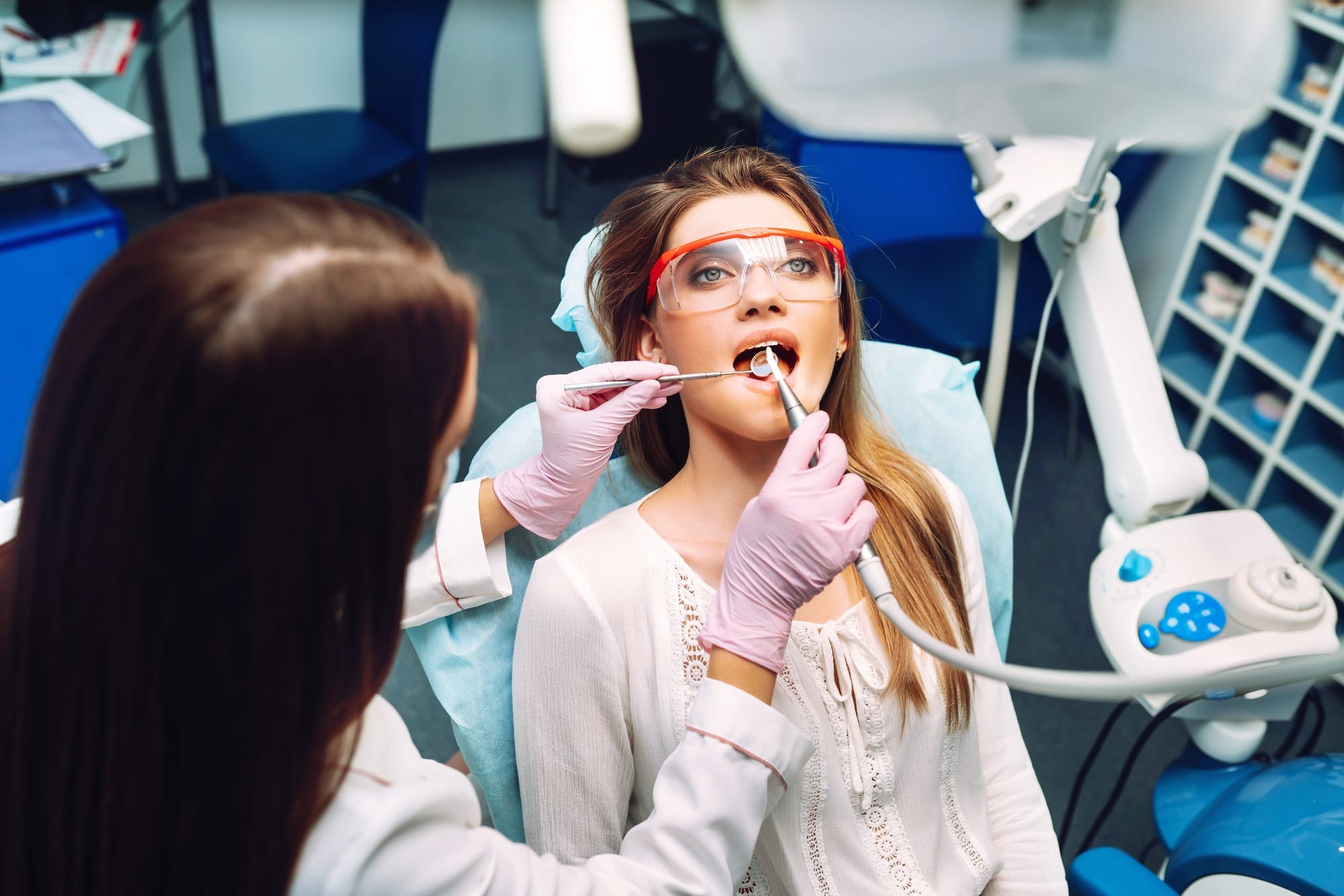 Young woman at the dentist's chair during a dental procedure. Overview of dental caries prevention. Young woman at the dentist's chair during a dental procedure. Overview of dental caries prevention.