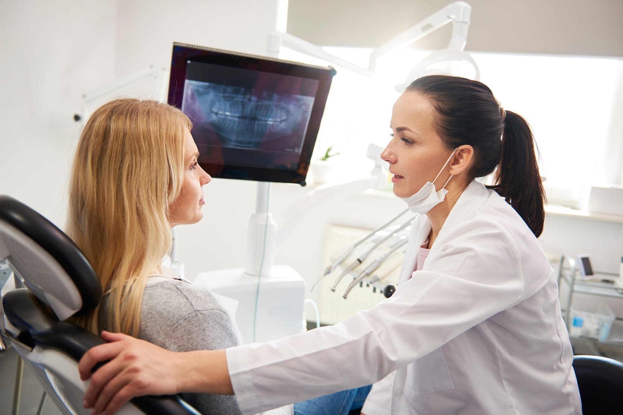 Dentist talking to young woman during dental checkup Dentist talking to young woman during dental checkup
