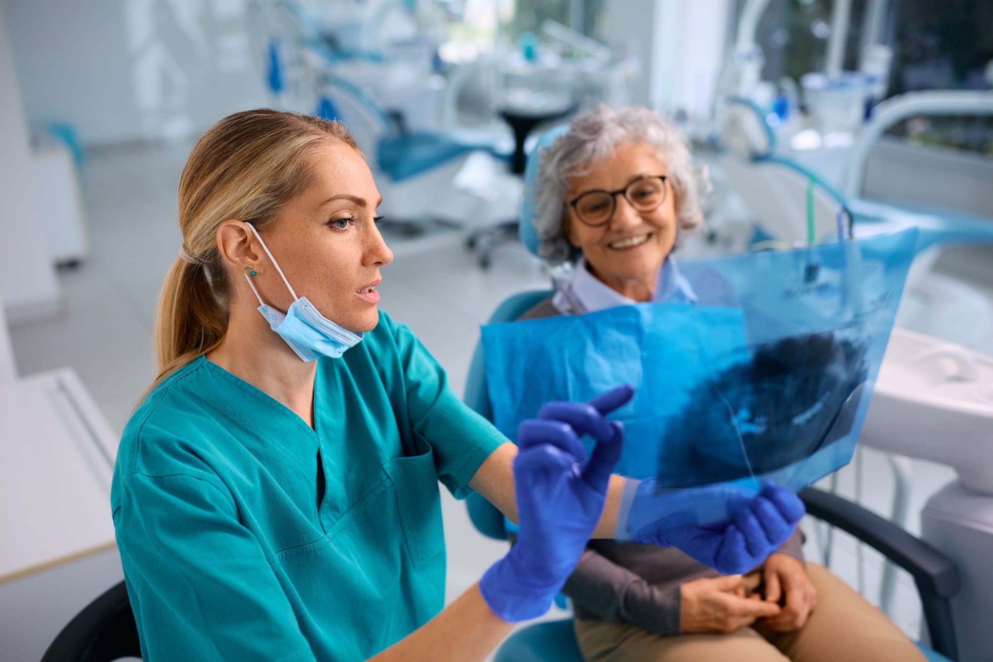 Female dentist showing to senior woman her orthopantomogram during dental appointment. Female dentist showing to senior woman her orthopantomogram during dental appointment.