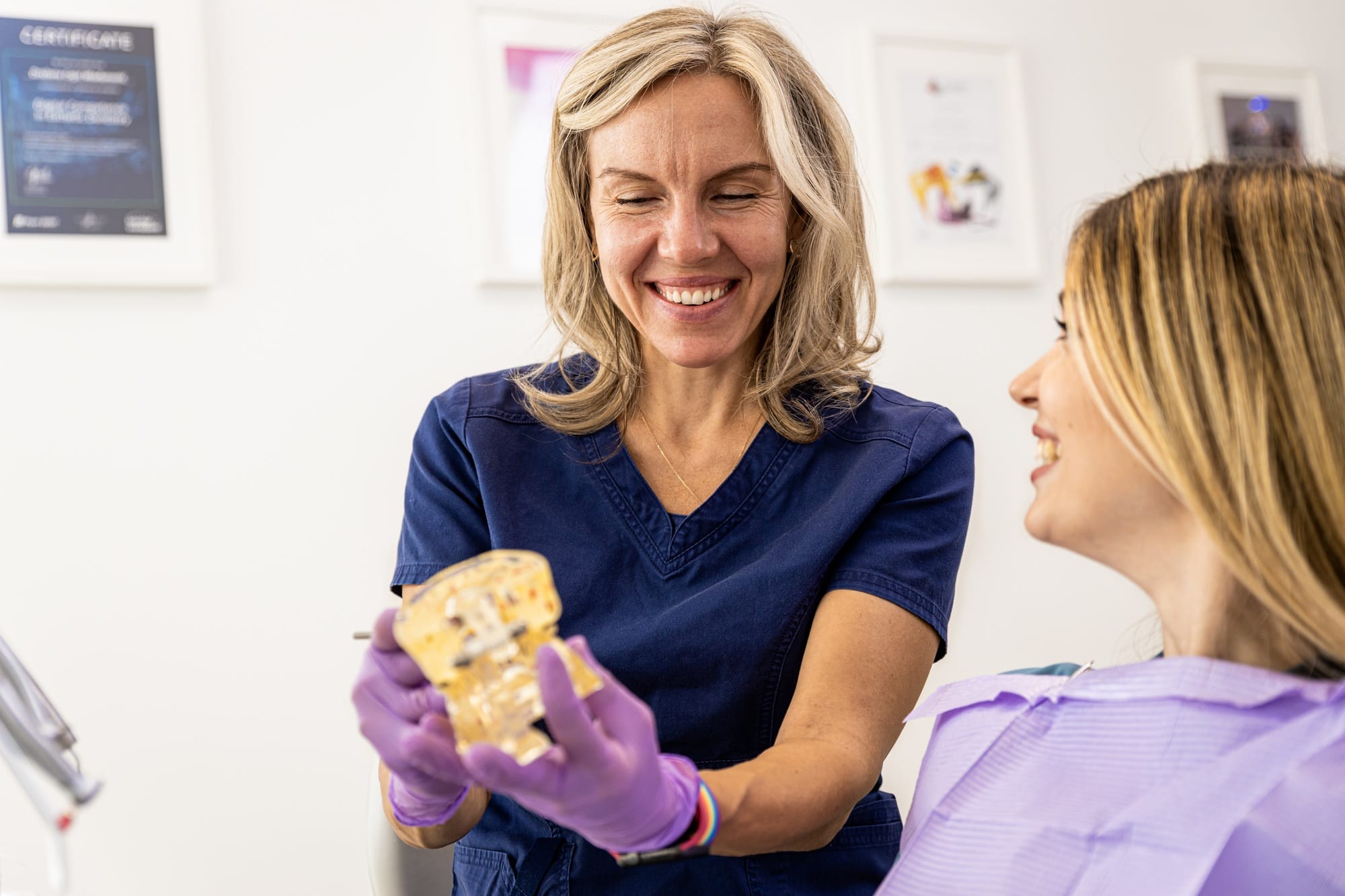 Female dentist takling with patient showing theet implant in dental clinic. Female dentist takling with patient showing theet implant in dental clinic.