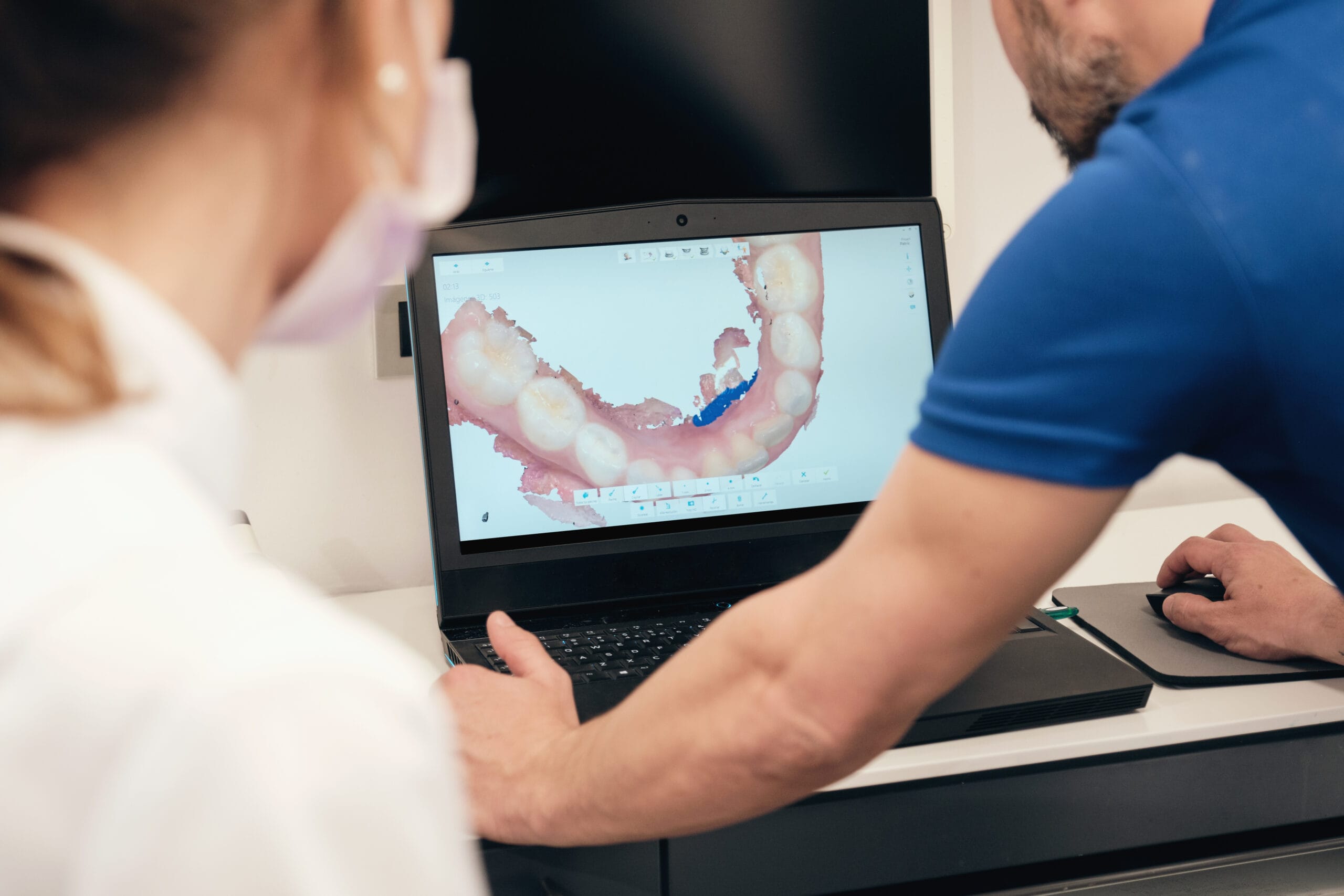 Dentist showing teeth scan to colleague Young woman getting dental treatment. dental clinic.