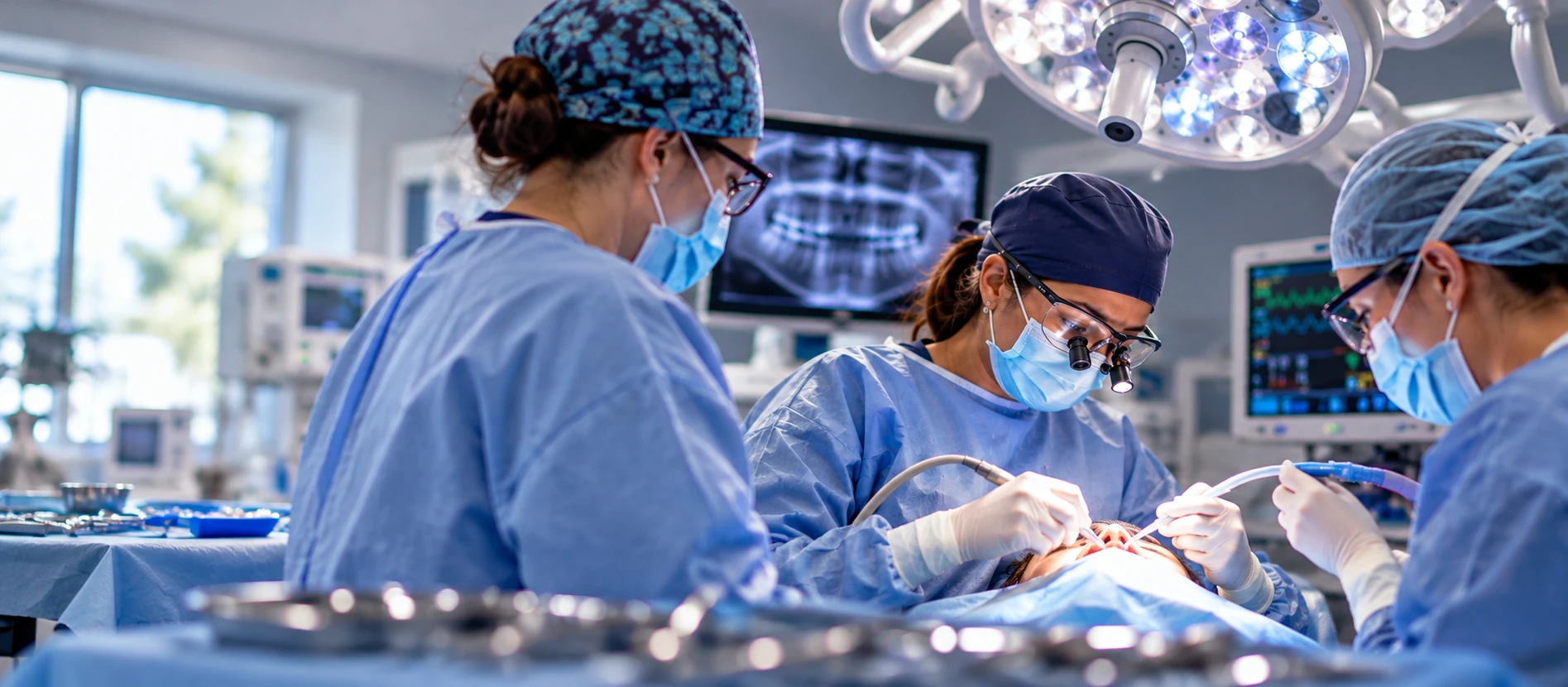 Dental team performing oral surgery in a modern treatment room